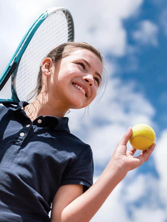 Shot from Below of a Girl Holding a Tennis Racket and Tennis Ball