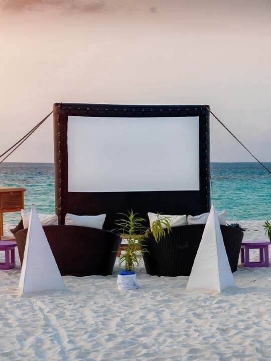 Movie Screen and Chairs On The Beach at Dusk